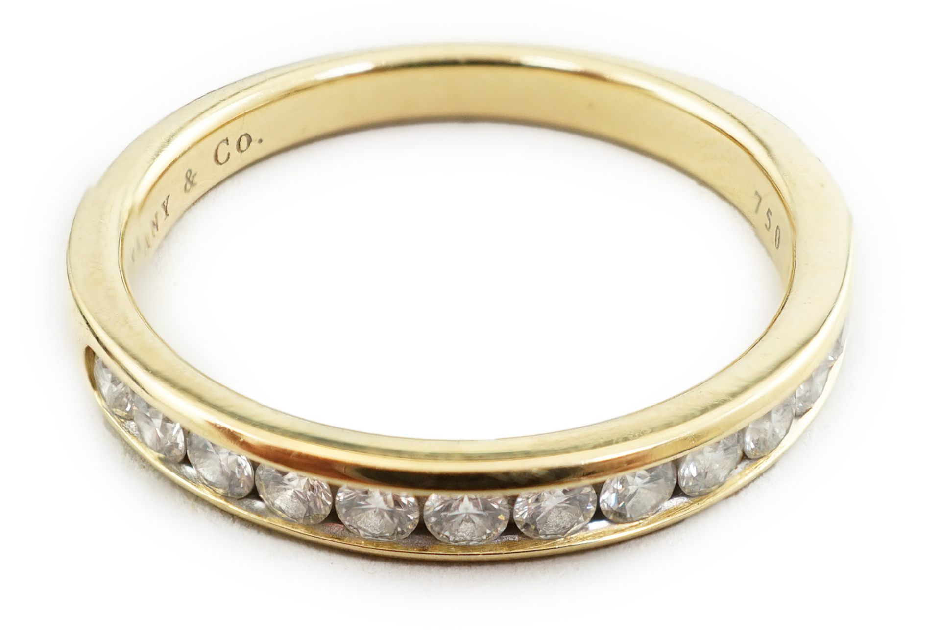 A modern Tiffany & Co 18k gold and channel set thirteen stone diamond half eternity ring